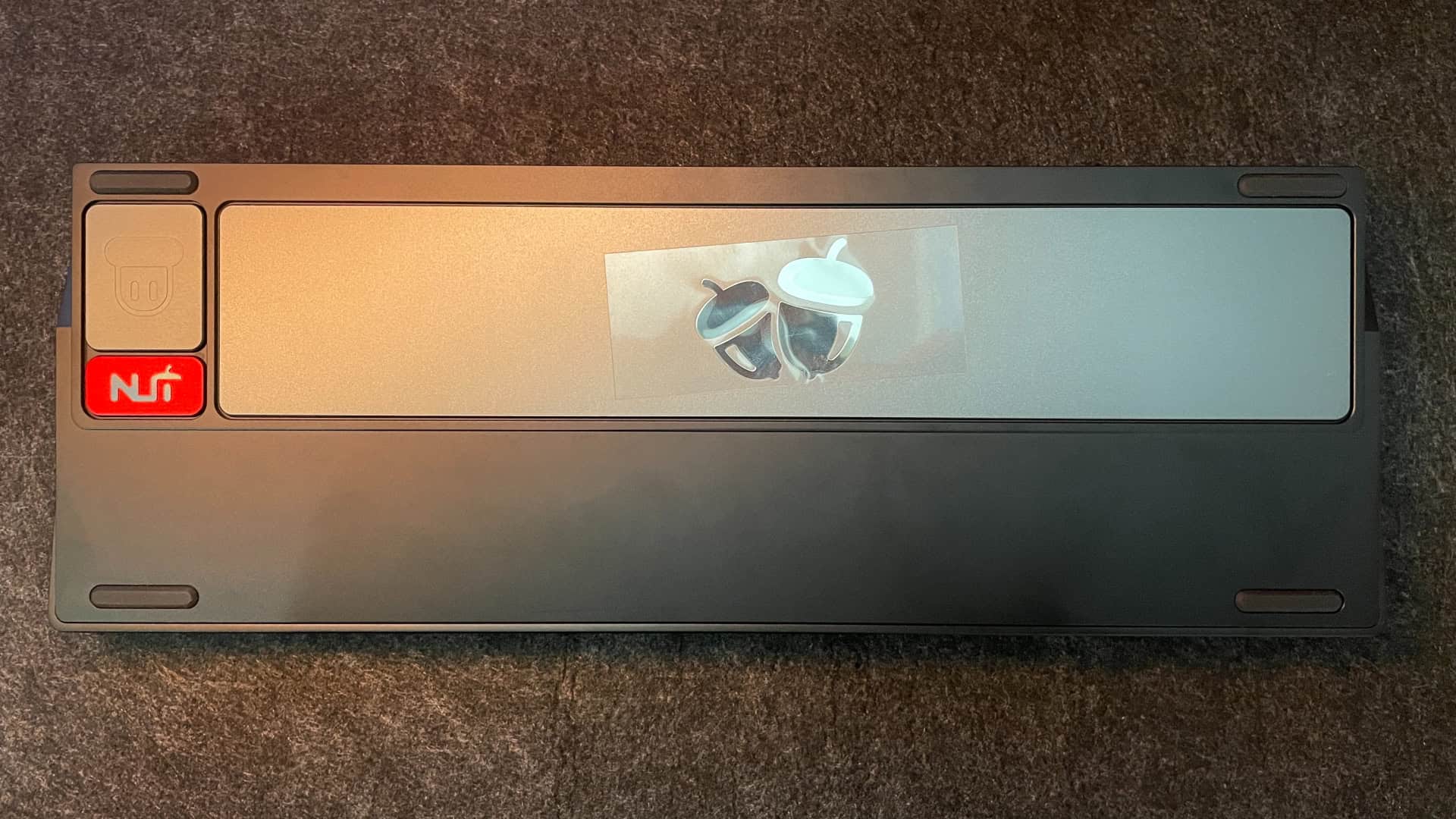Bottom of the NUT65 mechanical keyboard featuring decorative elements and the dongle compartment.