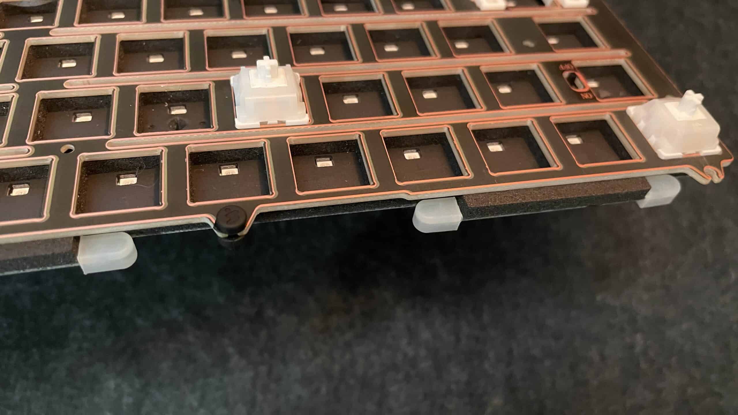 Close-up of the Weikav NUT65 mechanical keyboard showing both types of gasket mounts installed.