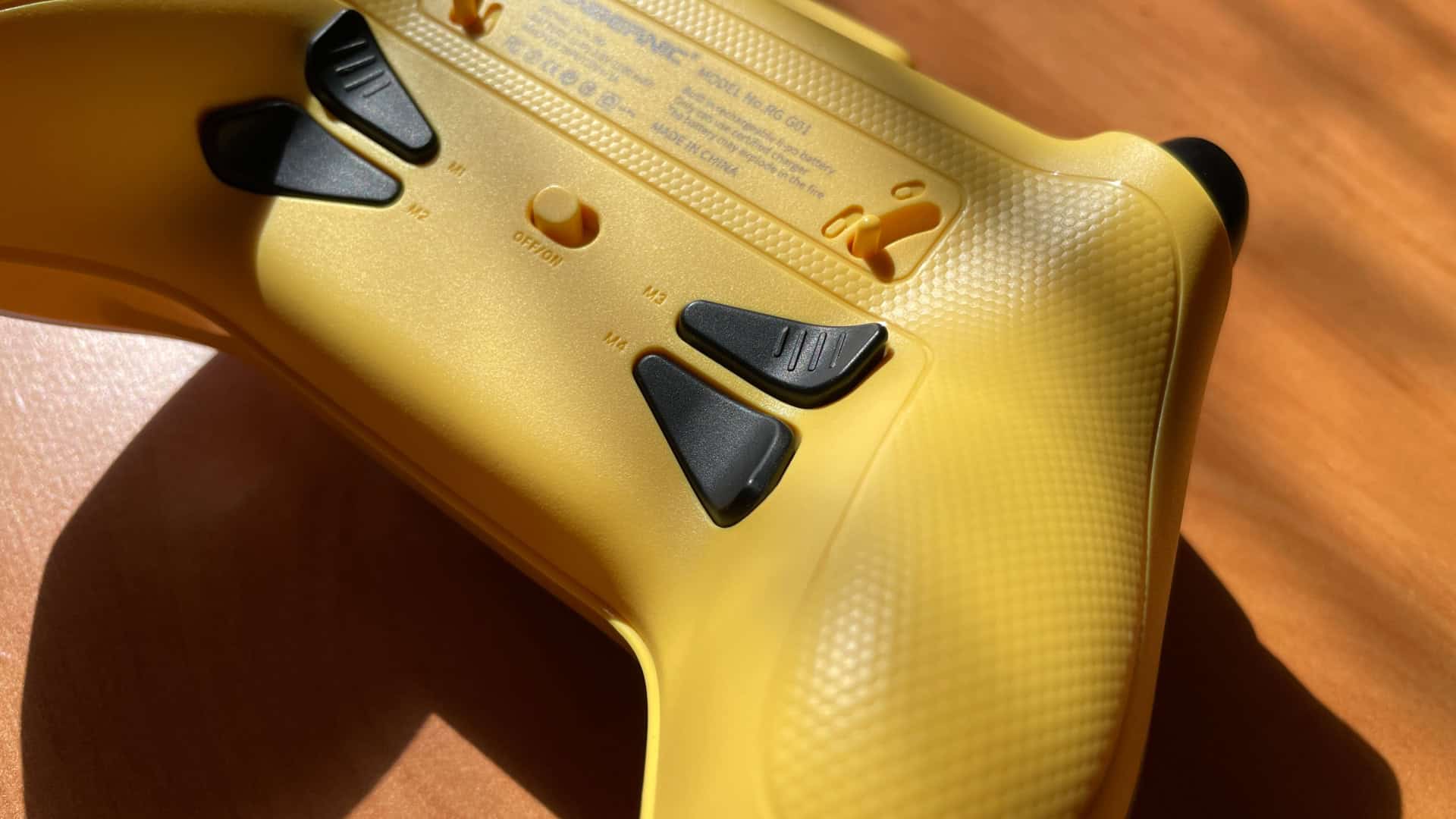 Close-up of the Anbernic RG G01 controller highlighting the additional back buttons, showing their placement, size, and design
