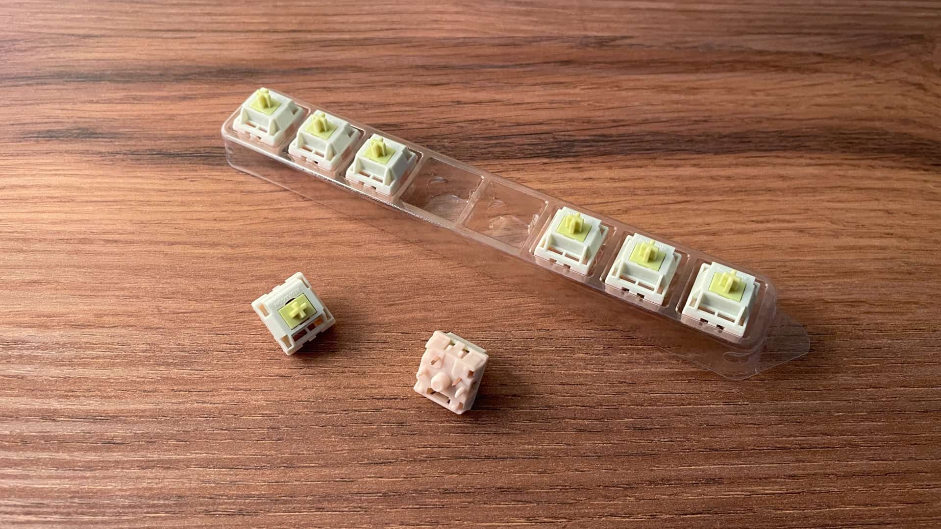 Close-up of spare mechanical switches for the Redragon Wyvern K761 Pro arranged in a plastic tray.
