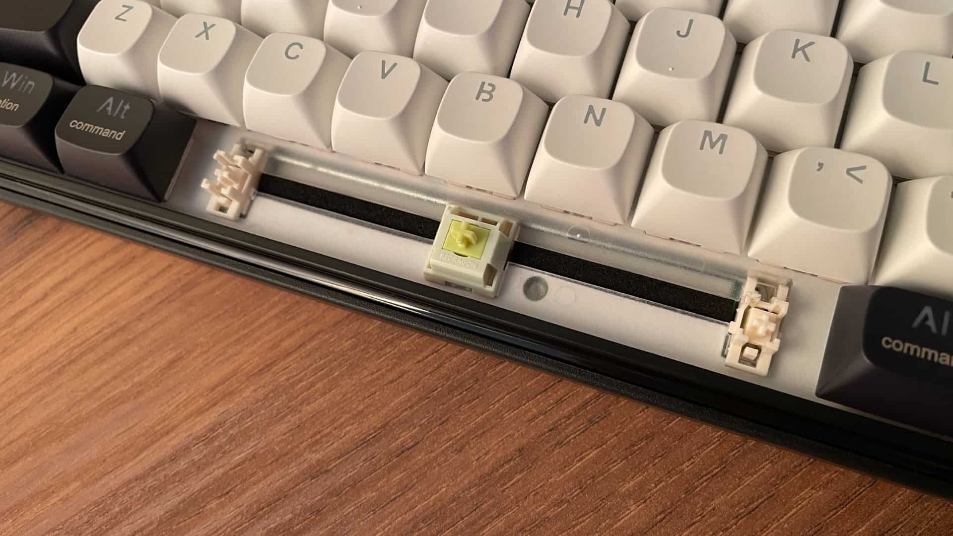 Close-up of the Redragon Wyvern K761 Pro mechanical keyboard with the spacebar removed, showing additional foam dampening in the stabilizer cutout.
