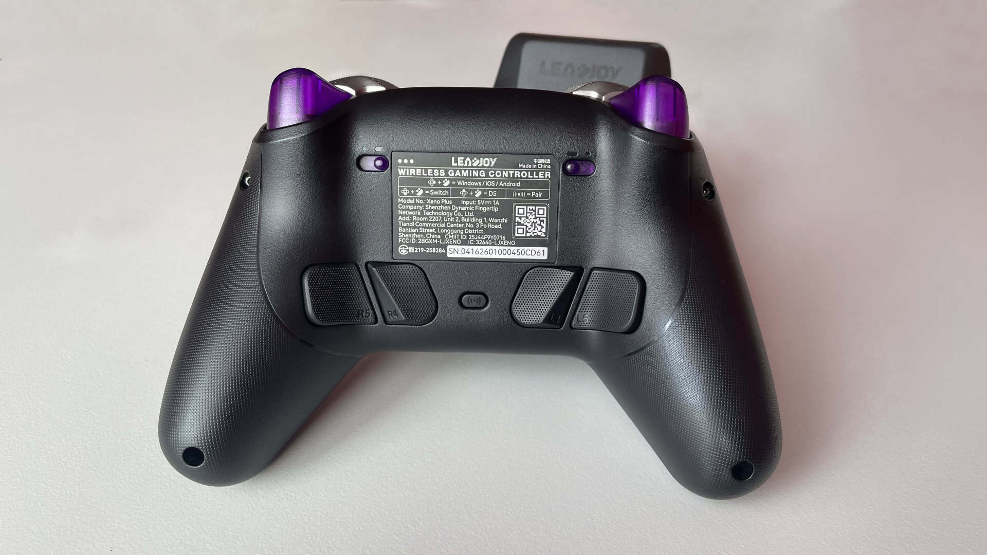 Back side of the Leadjoy Xeno Plus gaming controller, showing the rear grip texture, trigger mechanisms, and back buttons placement from a close-up perspective.