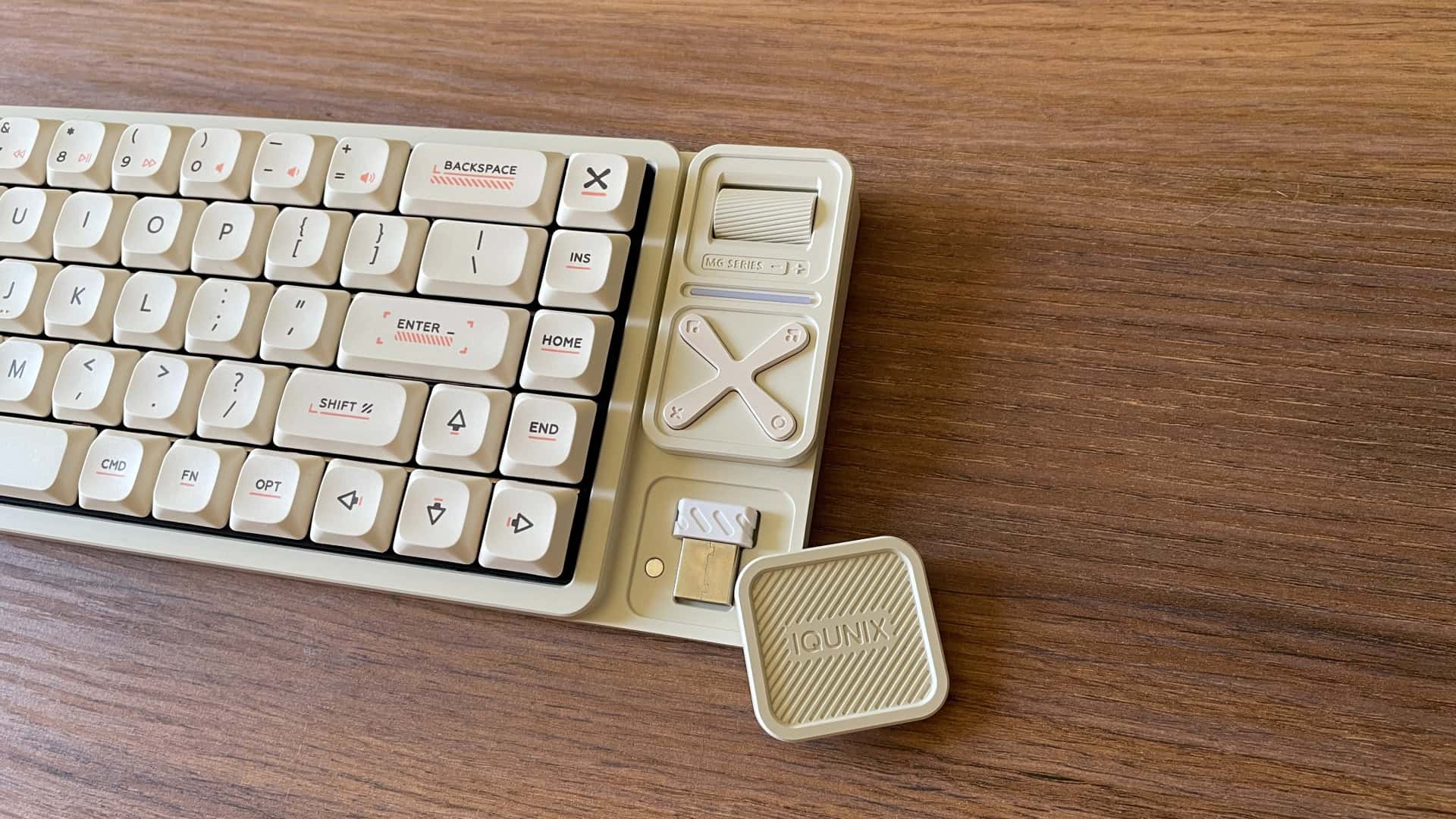 Close-up of the multimedia module on the IQUNIX Magi65 Pro mechanical keyboard, showing the hidden storage compartment for the wireless dongle.