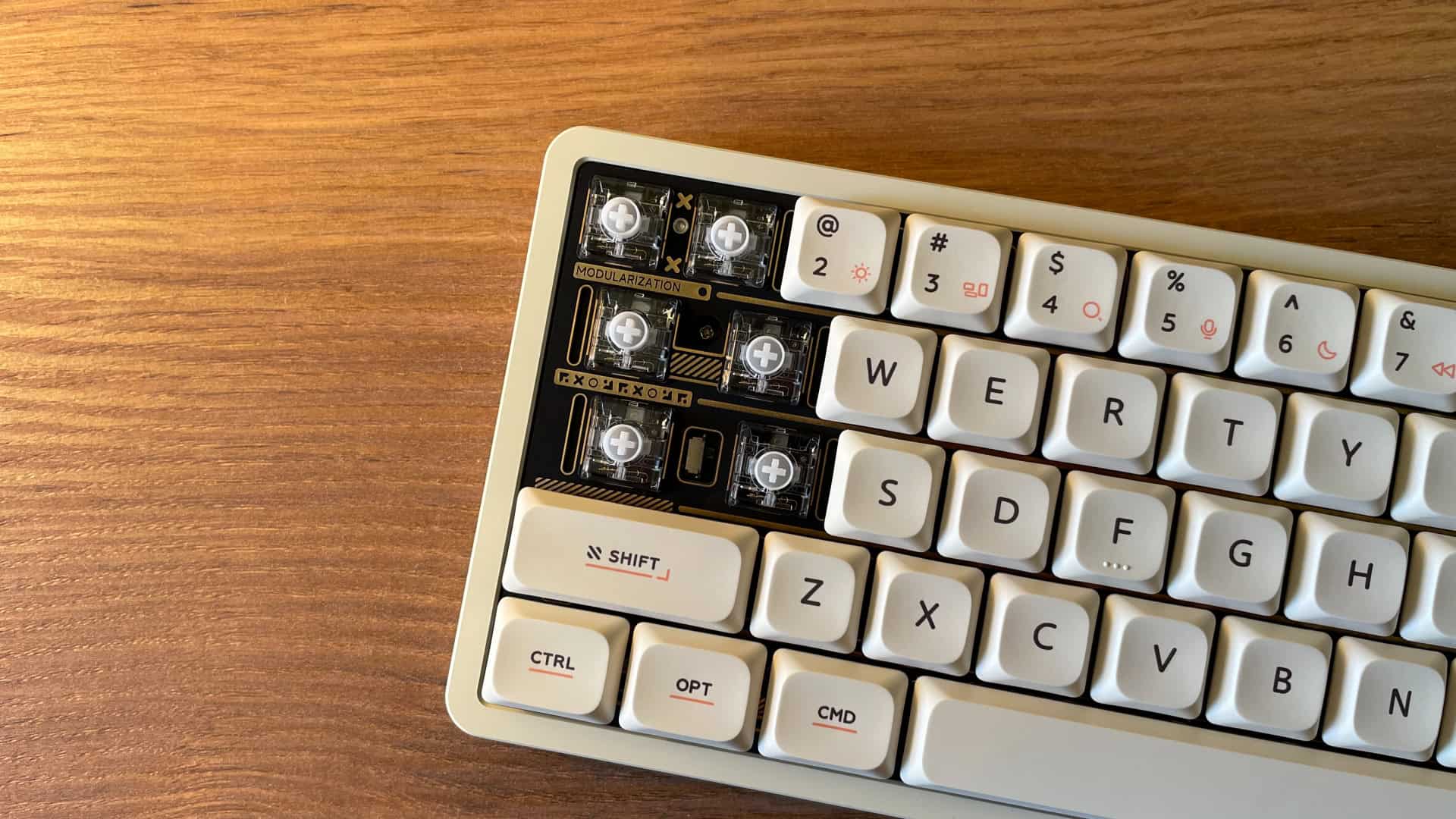 Close-up of the IQUNIX Magi65 mechanical keyboard plate showing premium gold decorative elements.