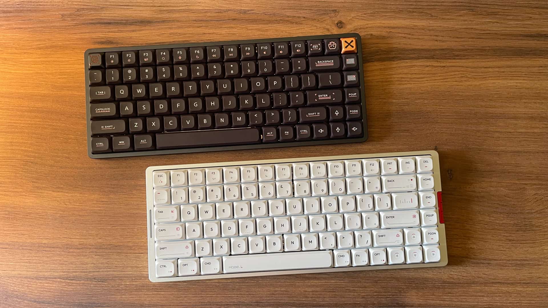 Side-by-side photo of the IQUNIX Magi75 mechanical keyboard placed next to the IQUNIX MQ80 keyboard for size and design comparison.