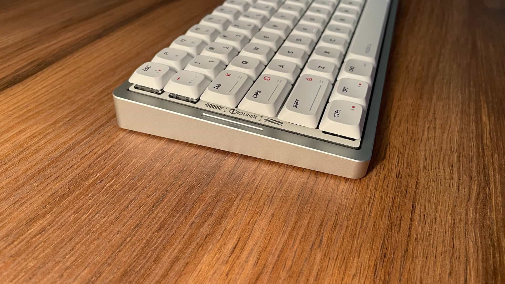 Side view of the IQUNIX MQ80 mechanical keyboard highlighting the typing angle and decorative design elements on the plate.