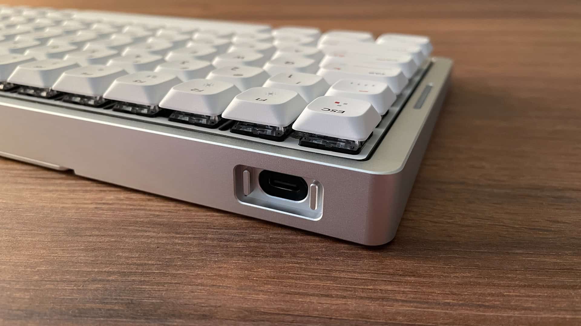 Close-up of the IQUNIX MQ80 keyboard’s USB port, featuring subtle decorative design elements around the connector.