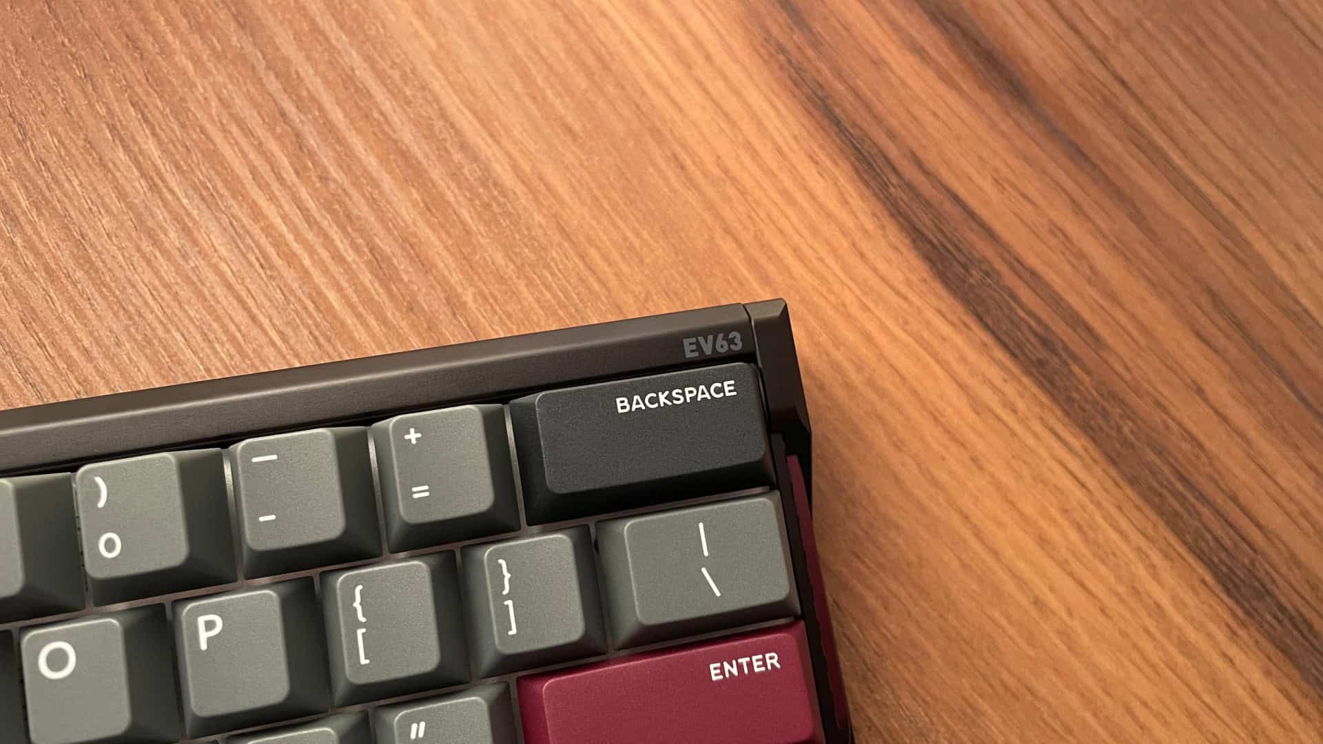 IQUNIX EV63 mechanical keyboard with a minimal design, showing a small “EV63” model marking in the upper-right corner and no other visible branding on the case.