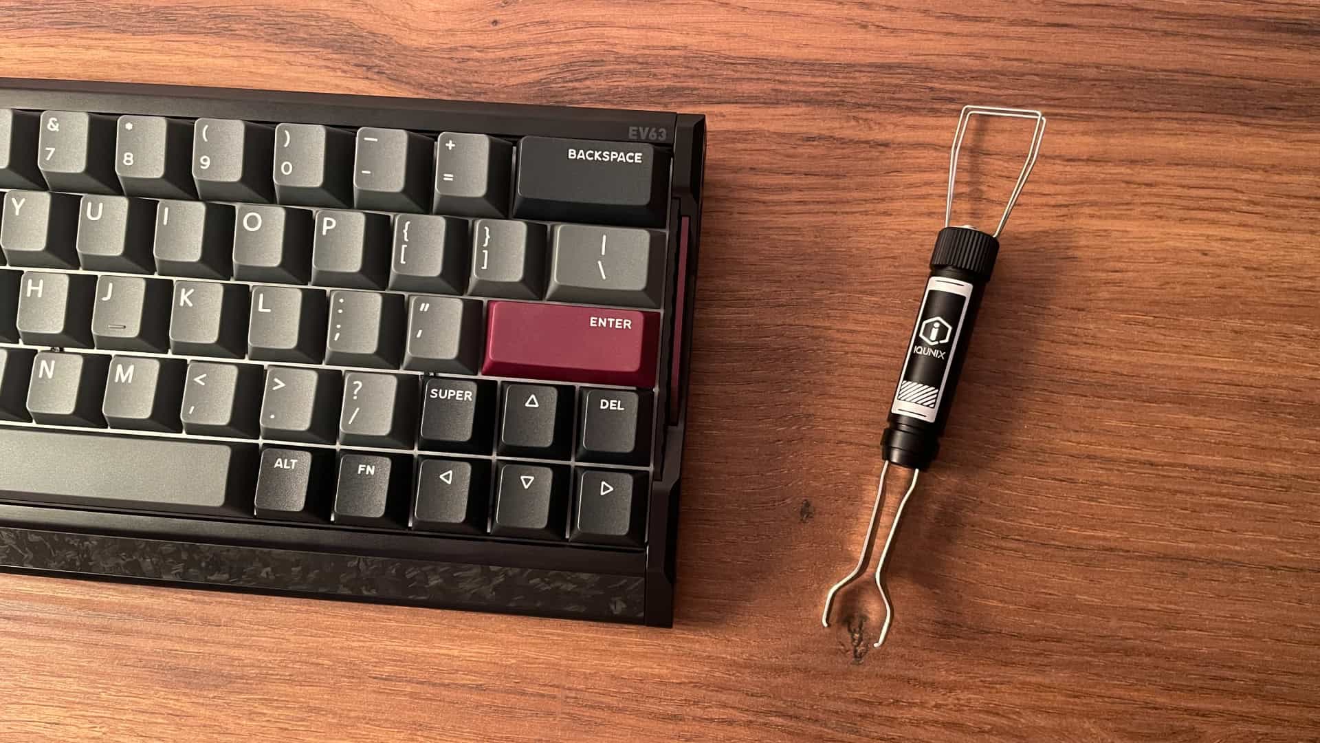 Close-up shot of the IQUNIX EV63 mechanical keyboard alongside its keycap puller accessory, highlighting the tool’s design and detailing.