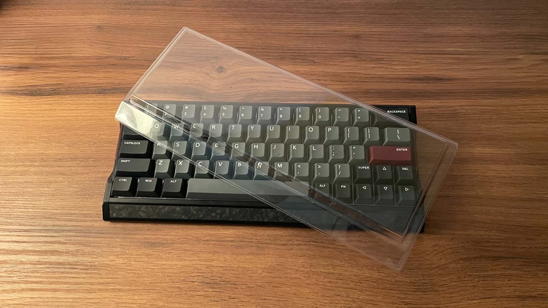 IQUNIX EV63 mechanical keyboard with a transparent dust cover placed on top.
