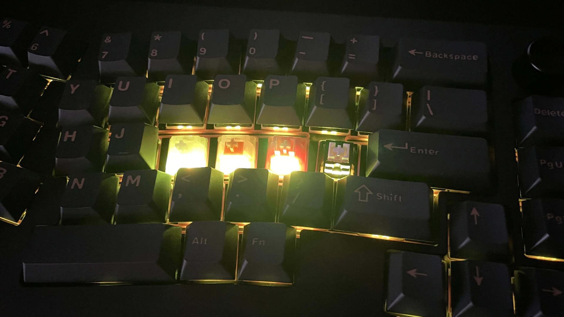 The Epomaker Tide Alice mechanical keyboard shown with different mechanical switches installed side by side, demonstrating how the RGB backlight brightness varies depending on the type of switches used.