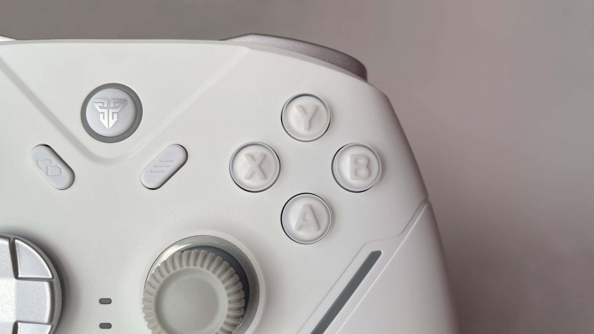 Close-up of the Fantech Zenith Pro ABXY face buttons showing layered construction with molded symbols sealed under a clear protective top layer.