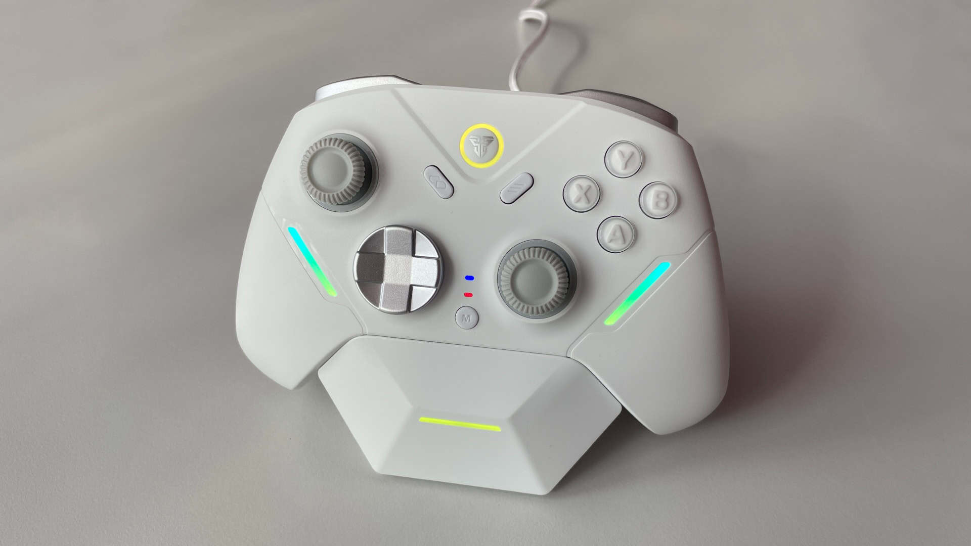 Fantech Zenith Pro controller placed on its charging dock, with synchronized RGB LED lighting between the dock strip and the controller’s dual light strips.