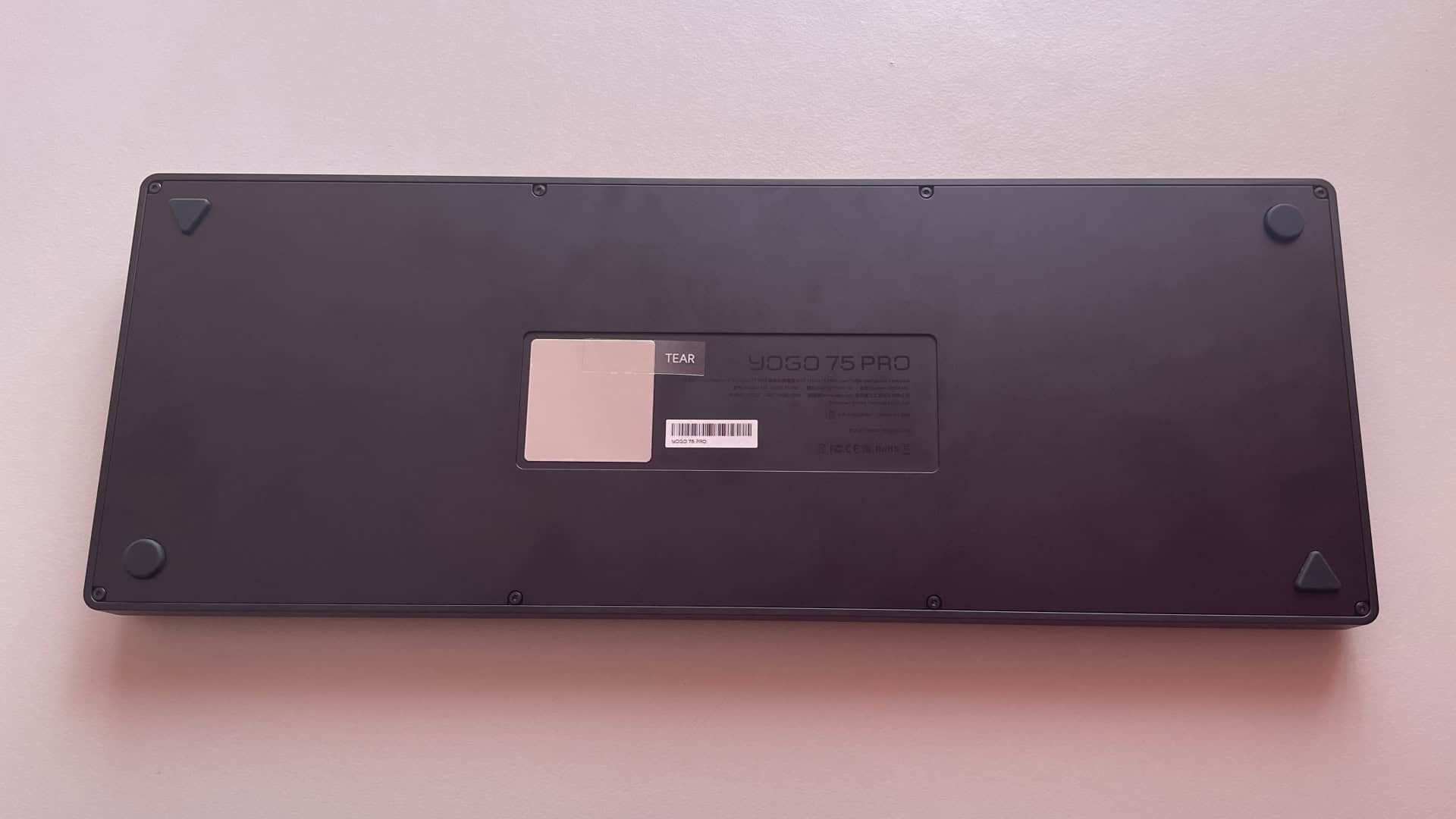 Underside view of the ATK Yogo 75 Pro low-profile mechanical keyboard showing the bottom case, feet mounts, and structural details.