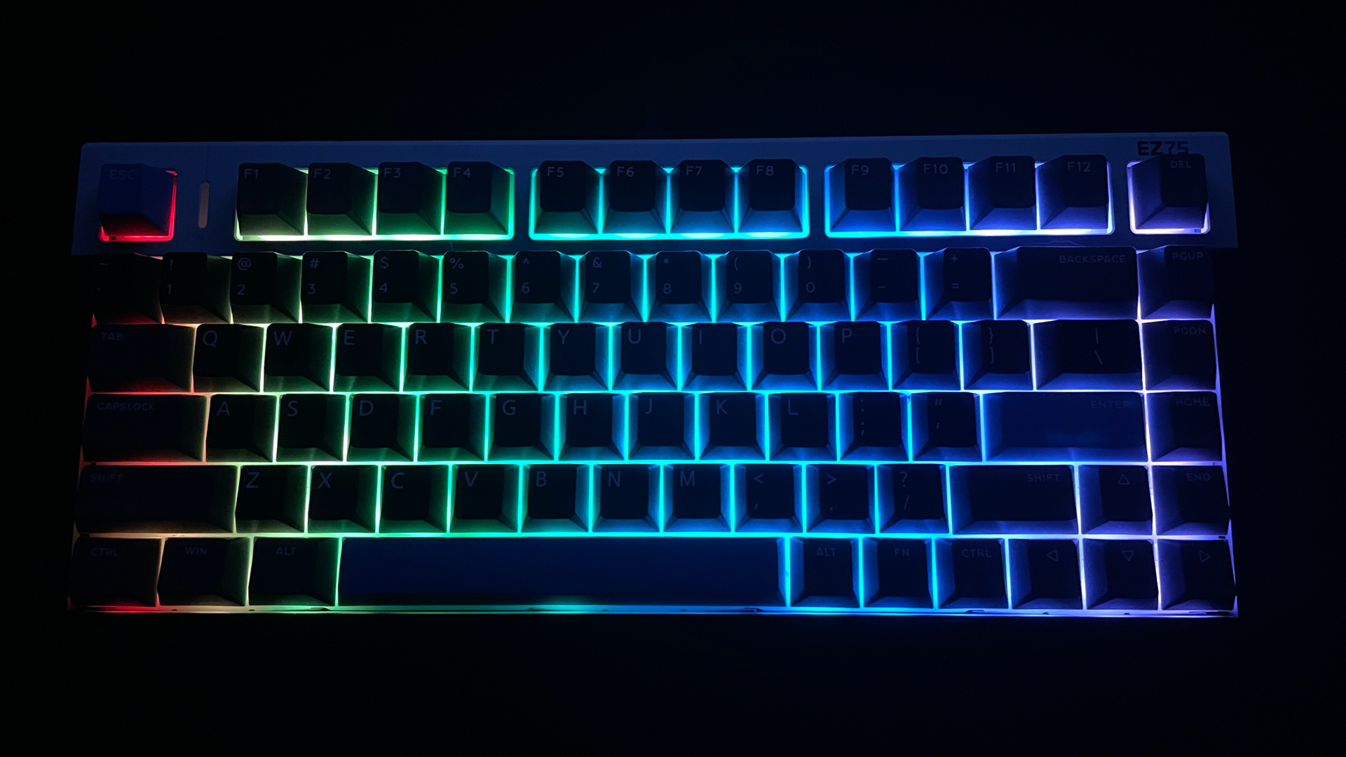 IQUNIX EZ75 Review – Gaming Performance Without Compromise 17 IQUNIX EZ75 mechanical keyboard with RGB backlighting illuminated in a dark environment, showcasing the lighting effects across the keys.