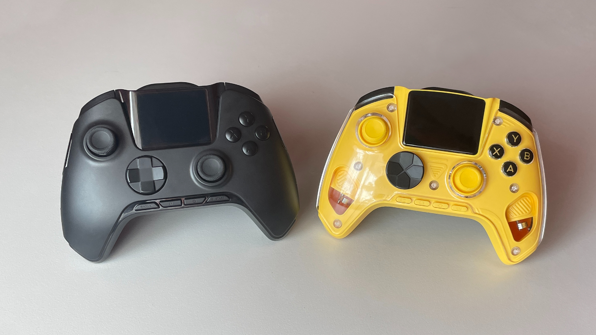 Front view of the Manba One V2 and Anbernic RG G01 controllers placed side by side for comparison.
