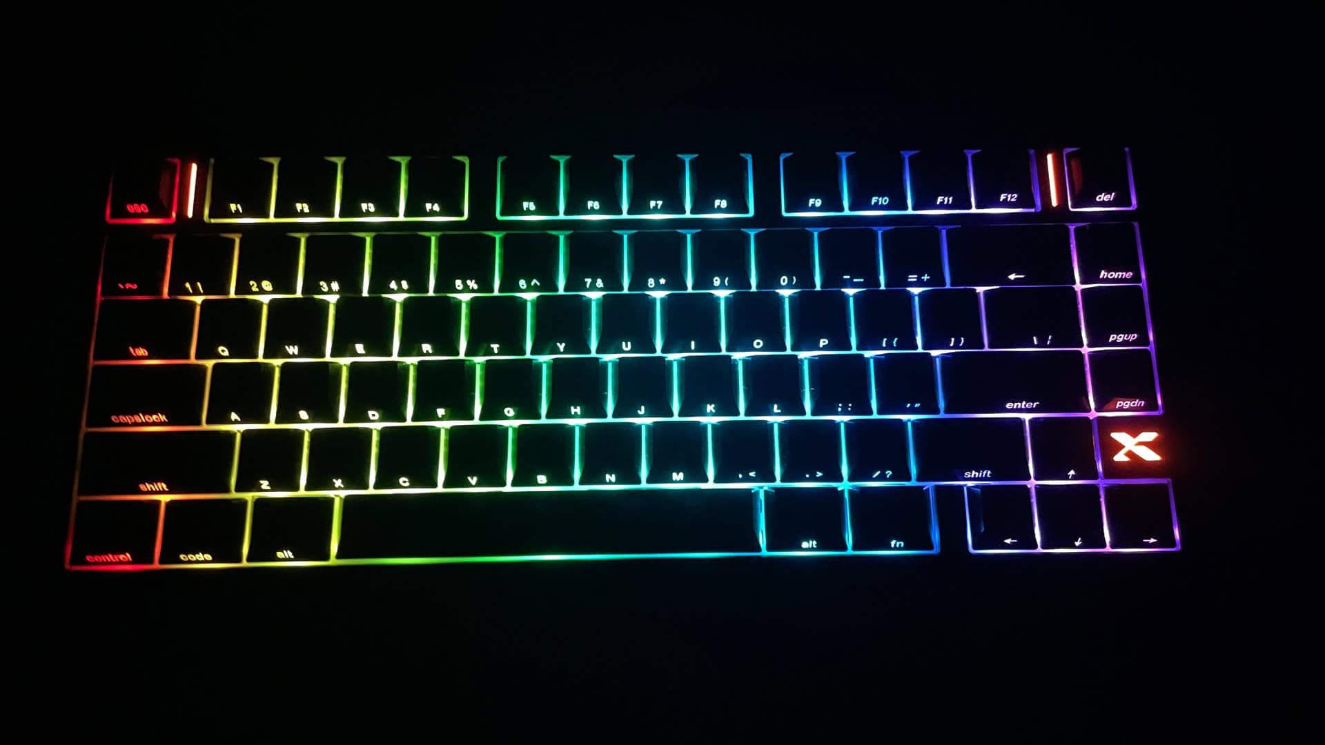 XVX L75 Air low-profile mechanical keyboard glowing in a dark environment, showcasing its RGB backlighting and illuminated design elements.