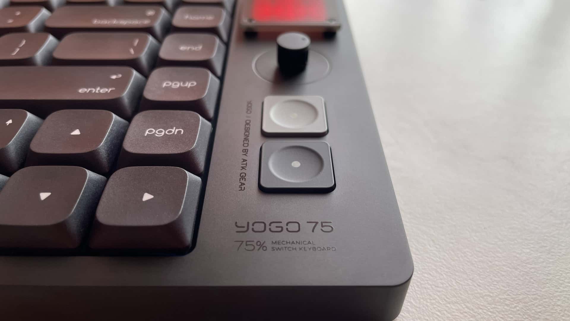 Close-up of the two additional buttons beneath the knob on the ATK Yogo 75 Pro keyboard, showing their placement and compact design.