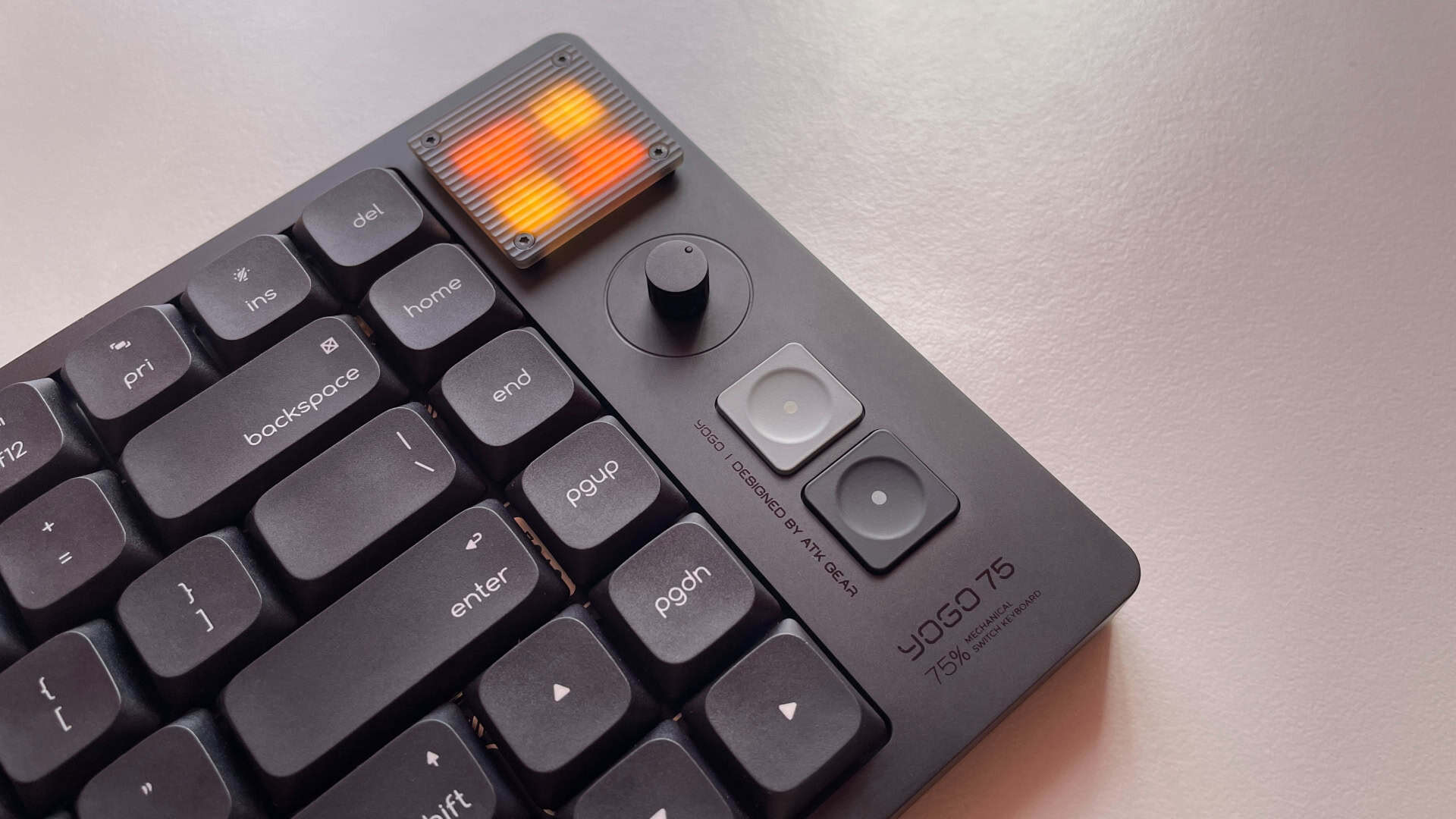 Close-up view of the ATK Yogo 75 Pro multimedia panel showing the control knob, pixel-style display, and dedicated controls.