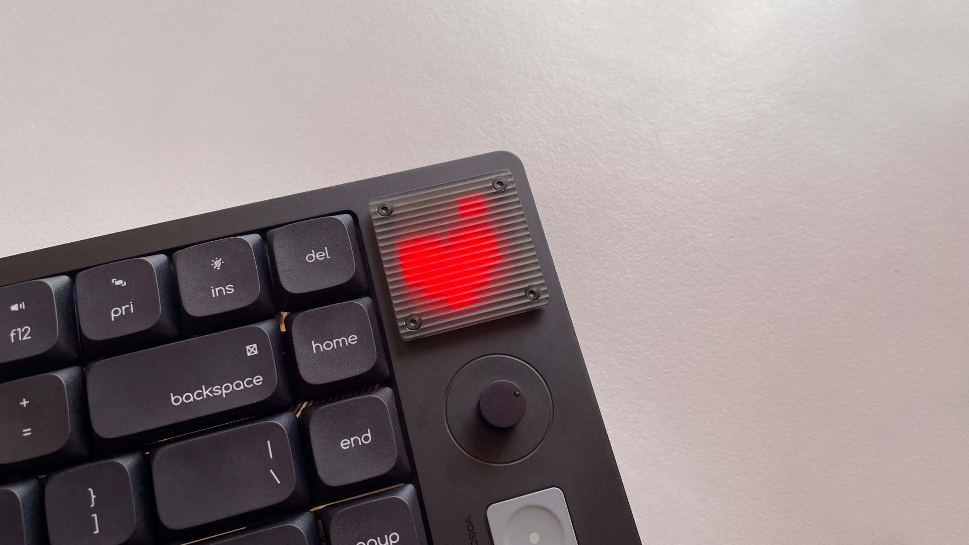 Close-up of the ATK Yogo 75 Pro's retro-inspired pixel display showing a heart animation behind the diffused glass panel.