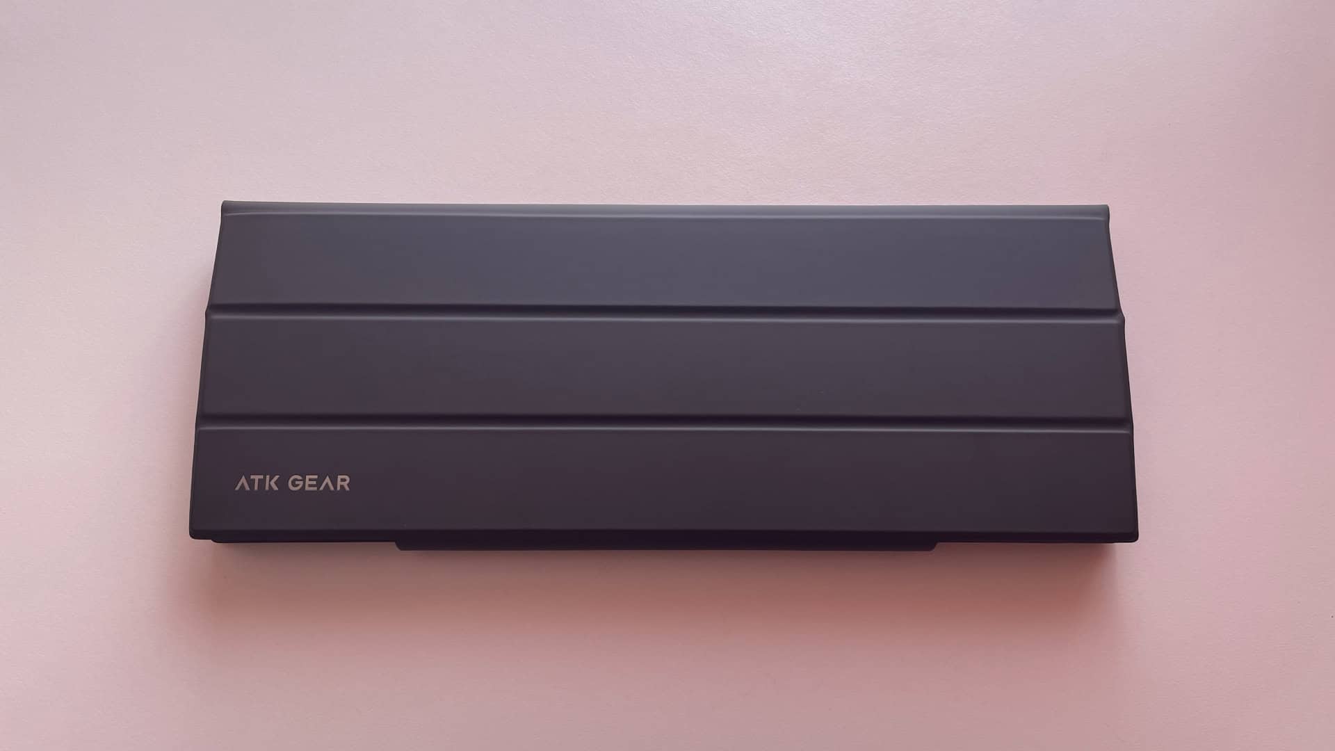 The ATK Yogo 75 Pro enclosed in its closed folio-style carrying case, providing a slim protective cover for transport.