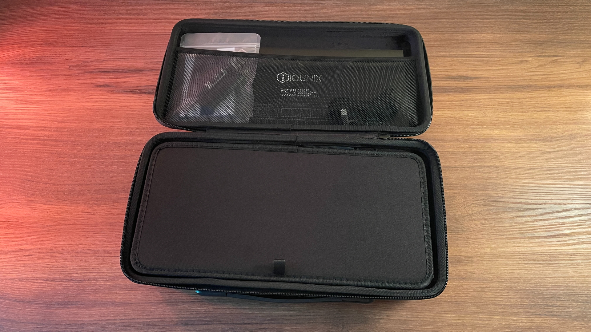IQUNIX EZ75 Review – Gaming Performance Without Compromise 4 Close-up of the inside of the IQUNIX EZ75 hard-shell carrying case highlighting the padded interior and custom compartments for the keyboard and accessories.