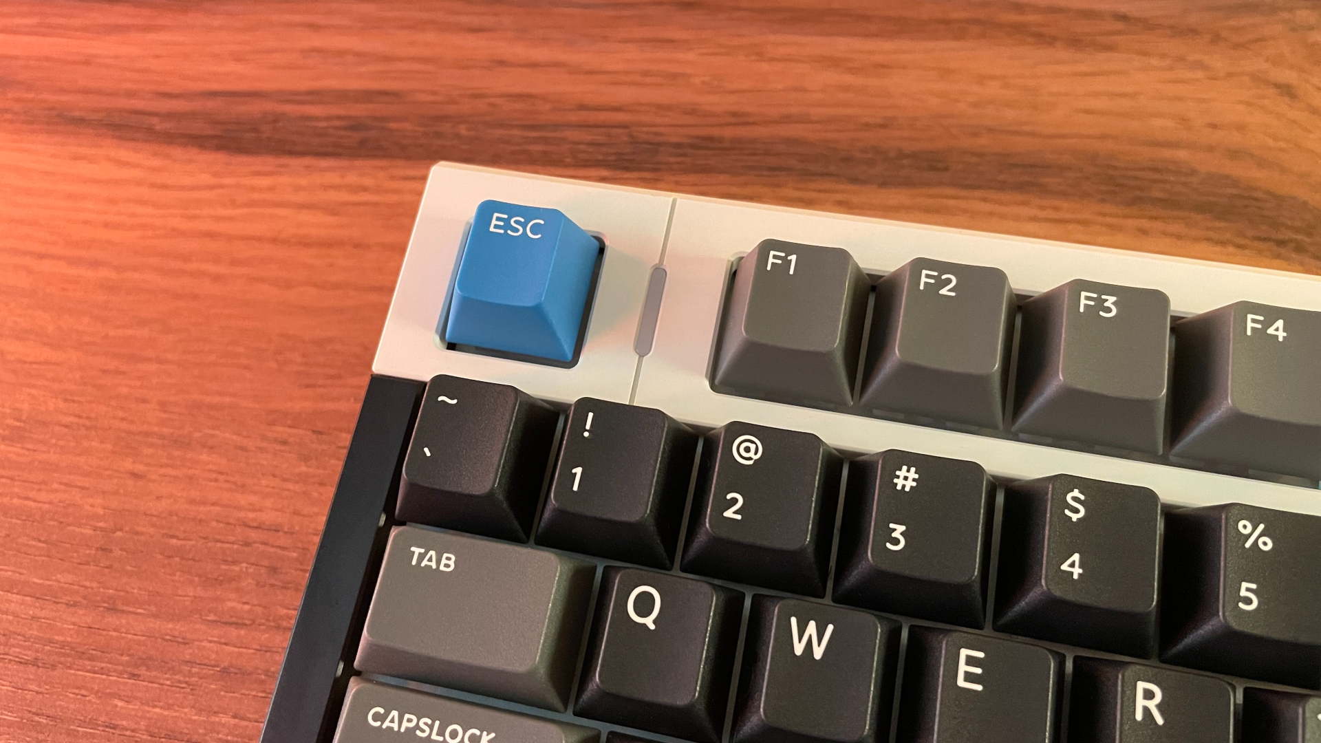 IQUNIX EZ75 Review – Gaming Performance Without Compromise 9 Close-up of the IQUNIX EZ75 highlighting the white electrophoretic-coated (E-coated) top section of the aluminum case and the dedicated Caps Lock LED indicator next to the Esc key.