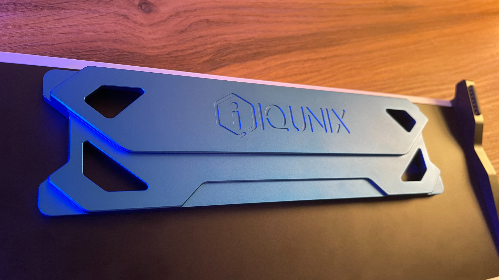 IQUNIX EZ75 Review – Gaming Performance Without Compromise 14 Close-up of the sculpted blue aluminum centerpiece on the underside of the IQUNIX EZ75, highlighting its geometric machining, chamfered edges, and engraved IQUNIX logo.