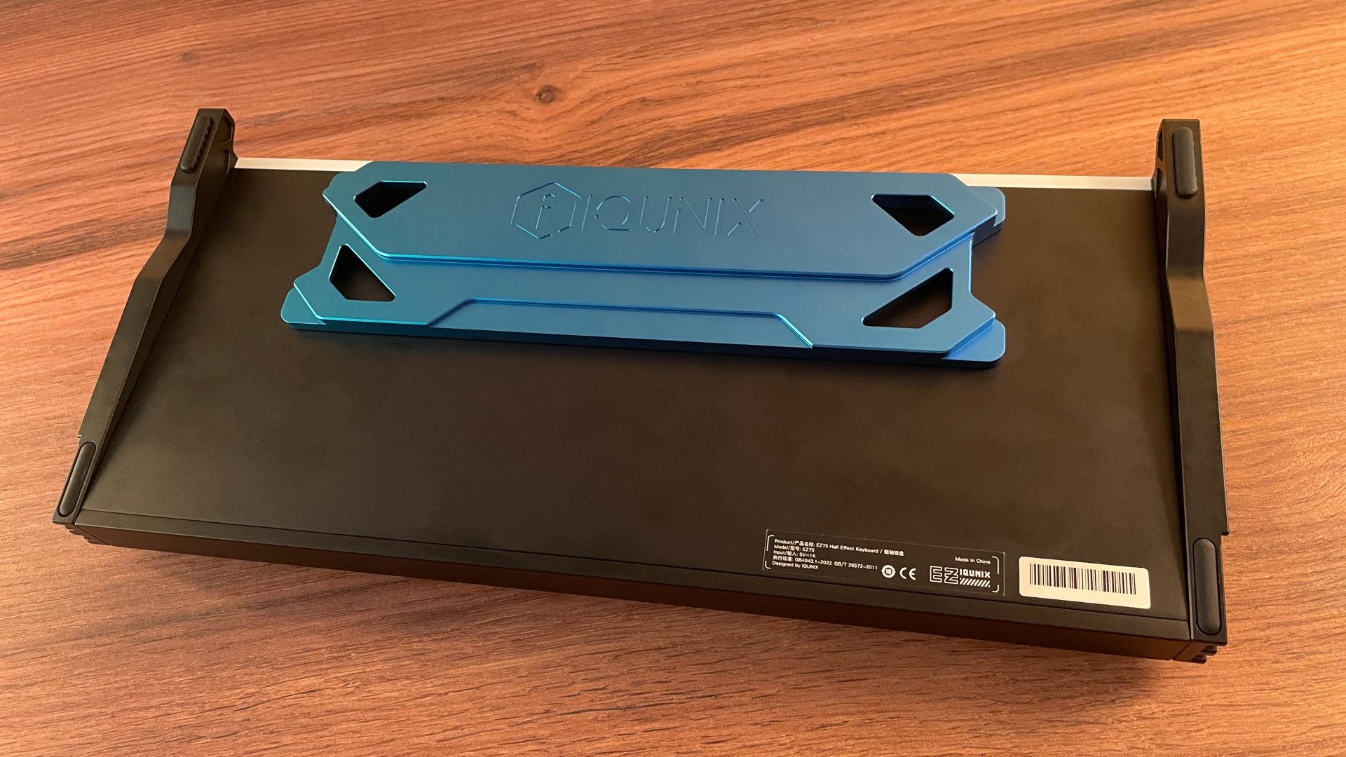 IQUNIX EZ75 Review – Gaming Performance Without Compromise 12 Bottom view of the IQUNIX EZ75 featuring the sculpted blue aluminum centerpiece with geometric machining, chamfered edges, and an engraved IQUNIX logo.