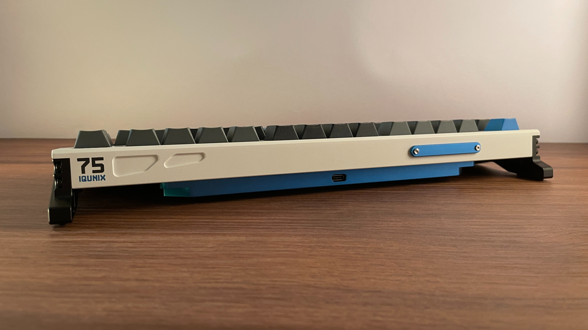 IQUNIX EZ75 Review – Gaming Performance Without Compromise 13 Rear view of the IQUNIX EZ75 showing the machined contours on the right side and the blue aluminum accent secured with two exposed screws on the left.