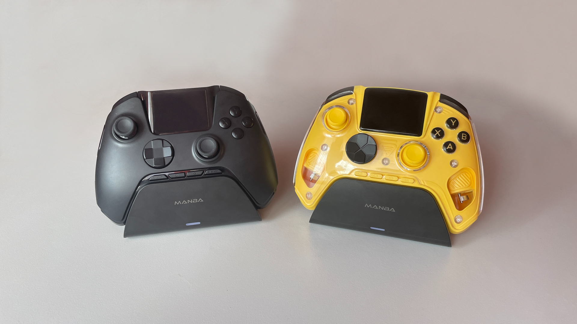 Manba One V2 and Anbernic RG G01 controllers shown from the front in a side-by-side comparison.