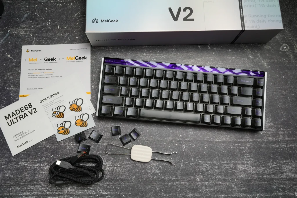 MelGeek MADE68 Ultra V2 unboxed alongside its retail packaging, extra keycaps, braided cable, and keycap puller