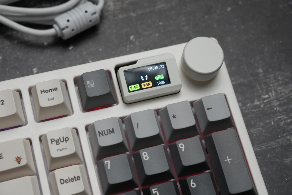 Close-up of the Keydous NJ98-CP V4 HE's magnetic docking screen showing time, battery percentage, and connection mode, next to the aluminum volume knob
