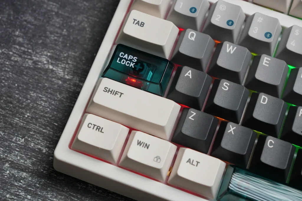 Close-up of the bottom-left corner of the Keydous NJ98-CP V4 HE showing the translucent Caps Lock key and RGB backlighting