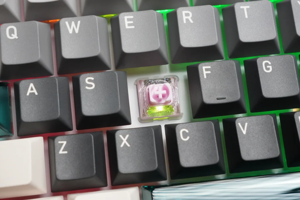 Close-up of a translucent pink magnetic switch installed on the Keydous NJ98-CP V4 HE, showing RGB lighting underneath