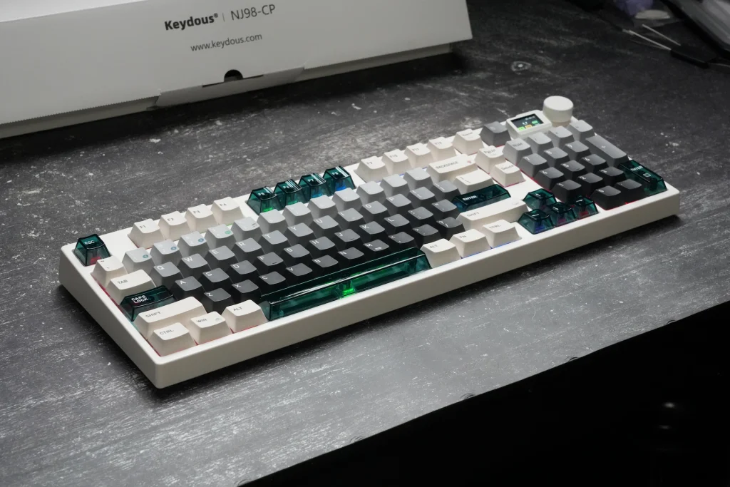 Angled view of the Keydous NJ98-CP V4 HE showing the full 98-key layout with translucent teal accent keycaps