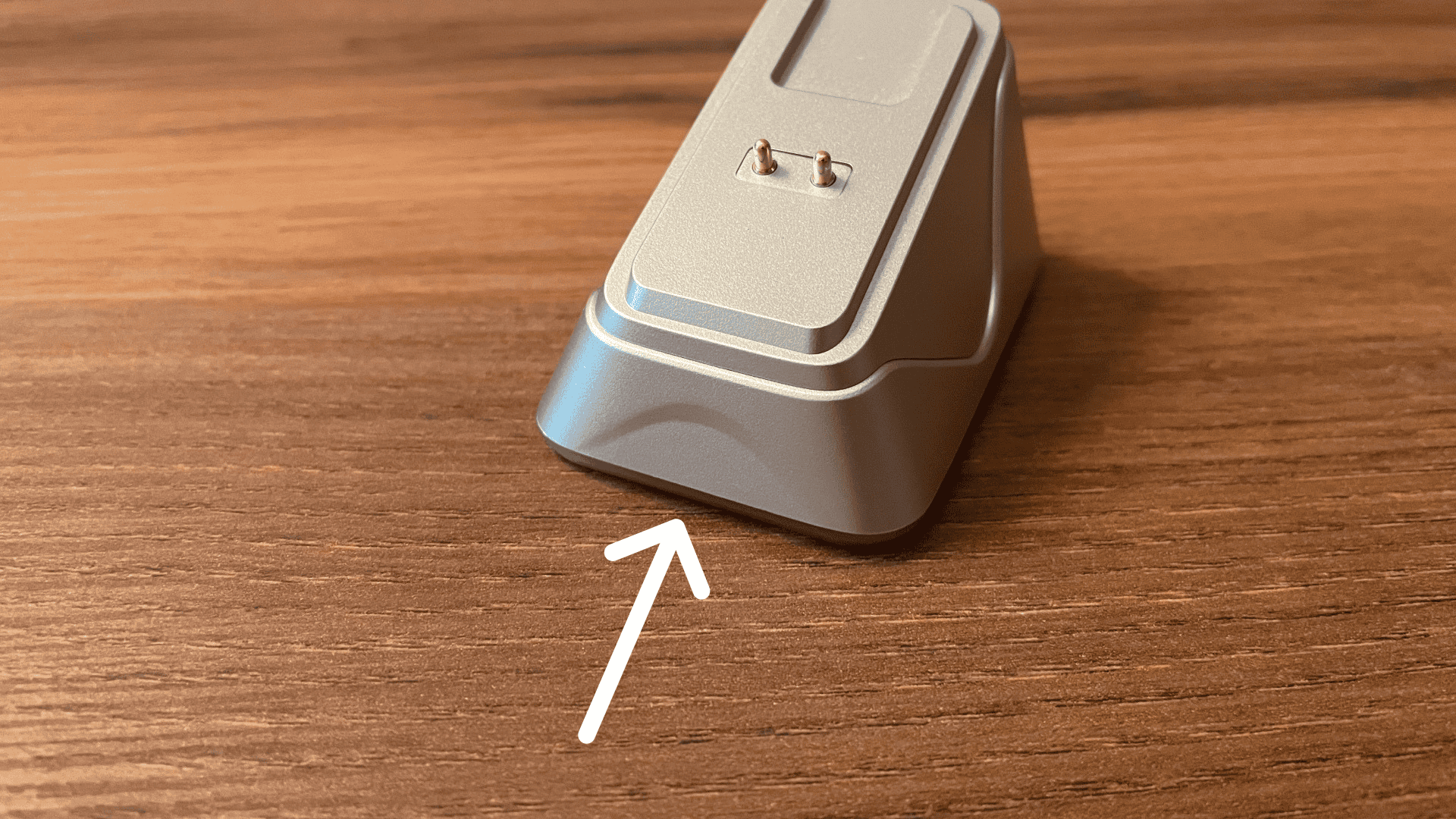 Close-up of the Epomaker Nex Pro charging dock with an arrow pointing to the touch-sensitive front panel used to control the dock's RGB lighting.