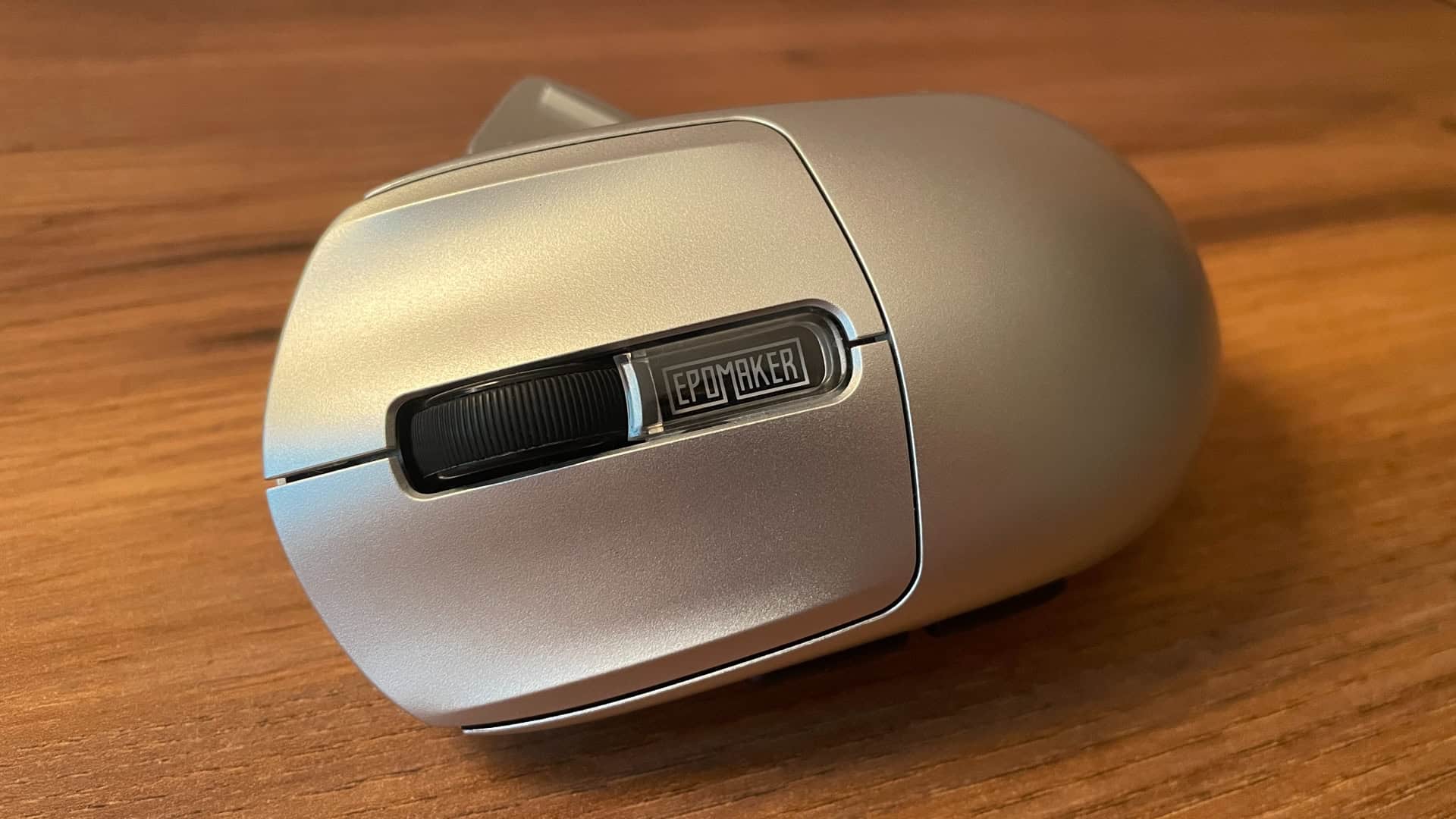 Close-up of the Epomaker logo insert positioned between the main buttons, just below the scroll wheel, serving as the mouse's only visual accent.