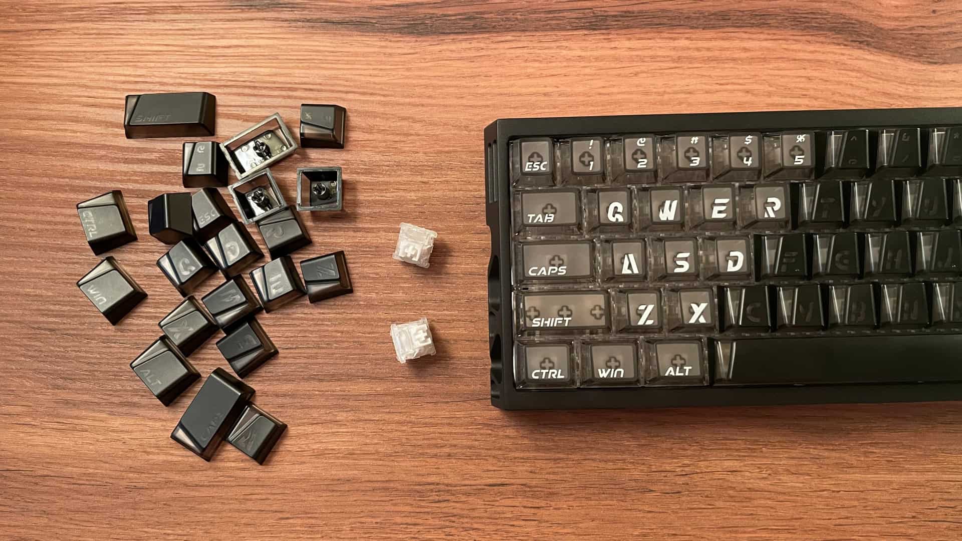 The XVX Trooper63 HE keyboard surrounded by keycaps and switches.