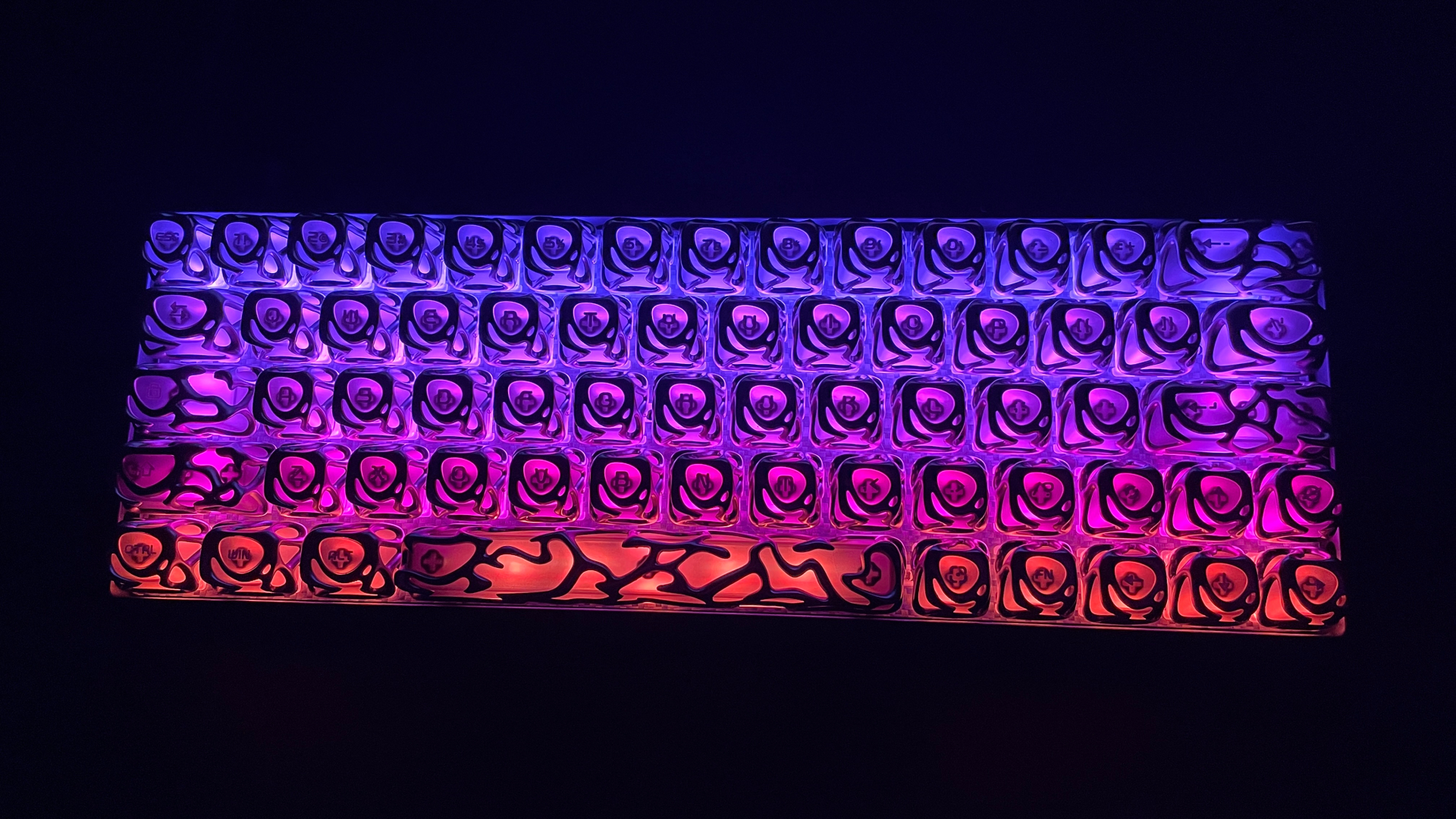 XVX Venom V2 Review – The Most Unique-Looking Keycaps? 14 XVX Venom V2 keycaps illuminated by RGB backlighting, showing how the light glows through the keycaps.