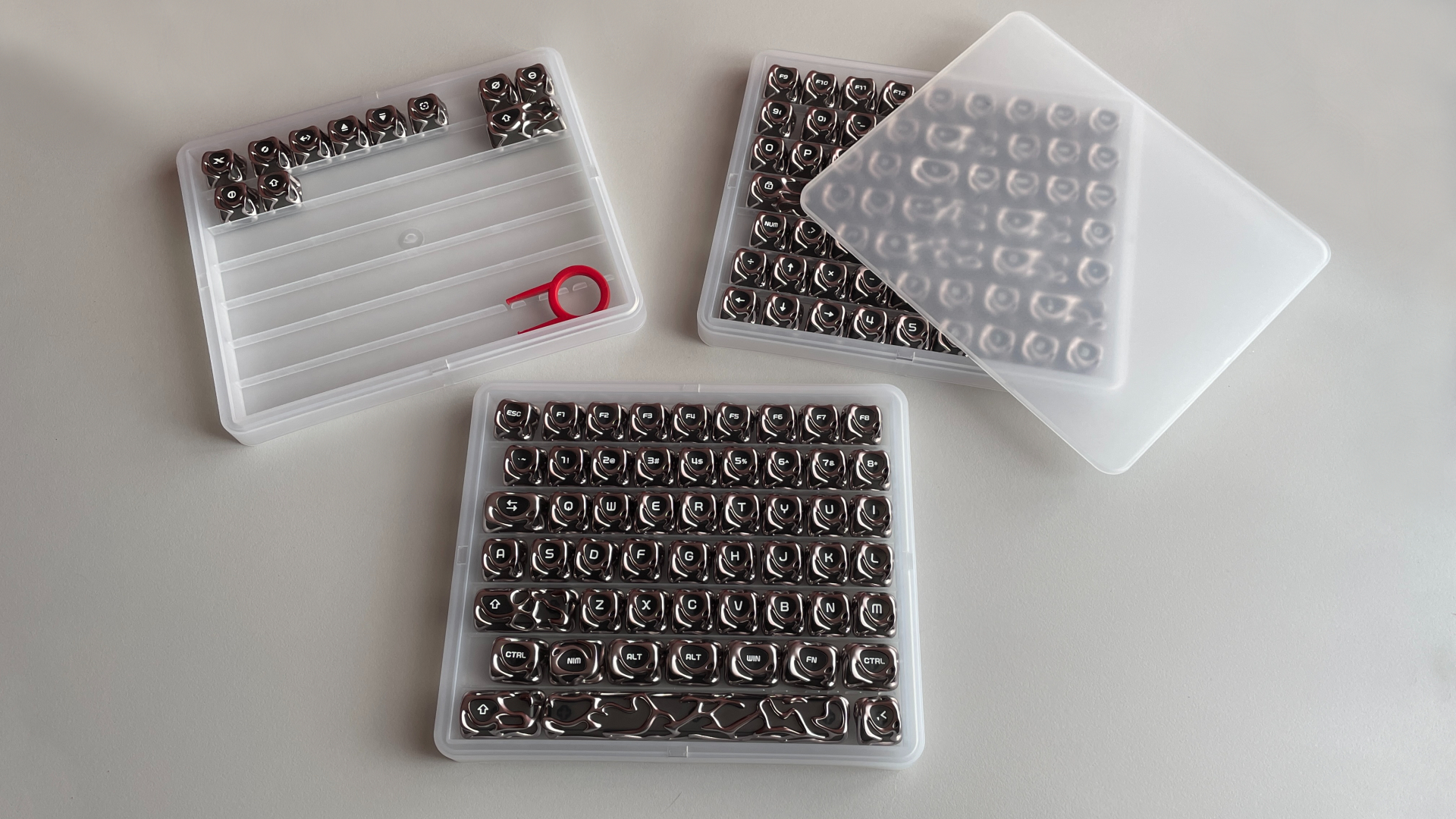 XVX Venom V2 Review – The Most Unique-Looking Keycaps? 4 All three trays of the XVX Venom V2 keycap set laid out on a table, showing alll 120-keycaps.