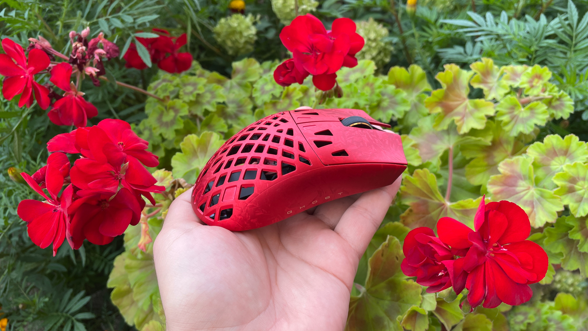 ATK Ghost Review – A Distinctive Take on the Lightweight Carbon Fiber Gaming Mouse 24 Red ATK Ghost gaming mouse placed among red flowers.