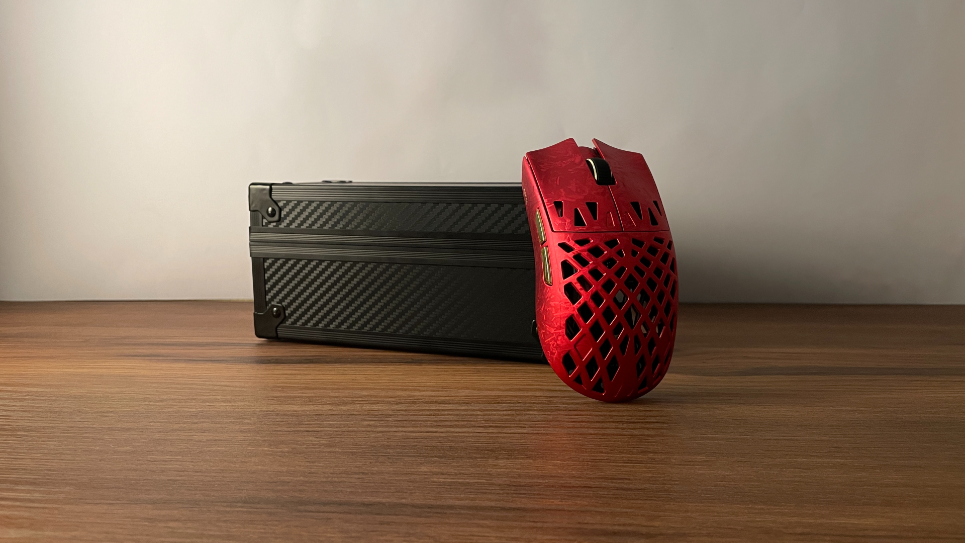 ATK Ghost Review – A Distinctive Take on the Lightweight Carbon Fiber Gaming Mouse 5 ATK Ghost gaming mouse leaning against its carbon fiber-textured storage case.