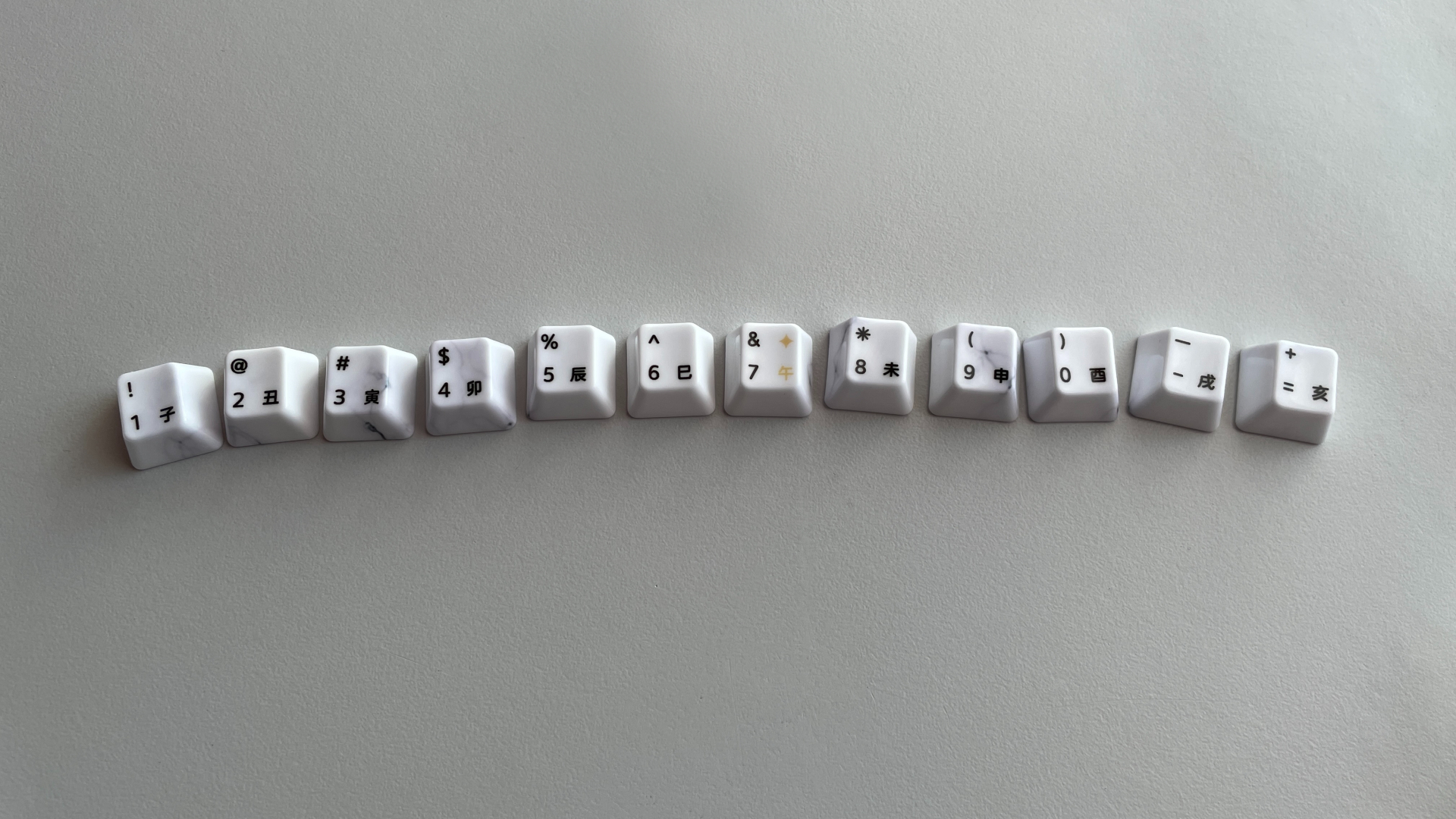 XVX Ceramic Keycaps Review: Year of the Horse Keycap Set 11 Twelve number-row keycaps with Chinese characters representing the zodiac animals, with the Horse character highlighted in gold on the 7 keycap.