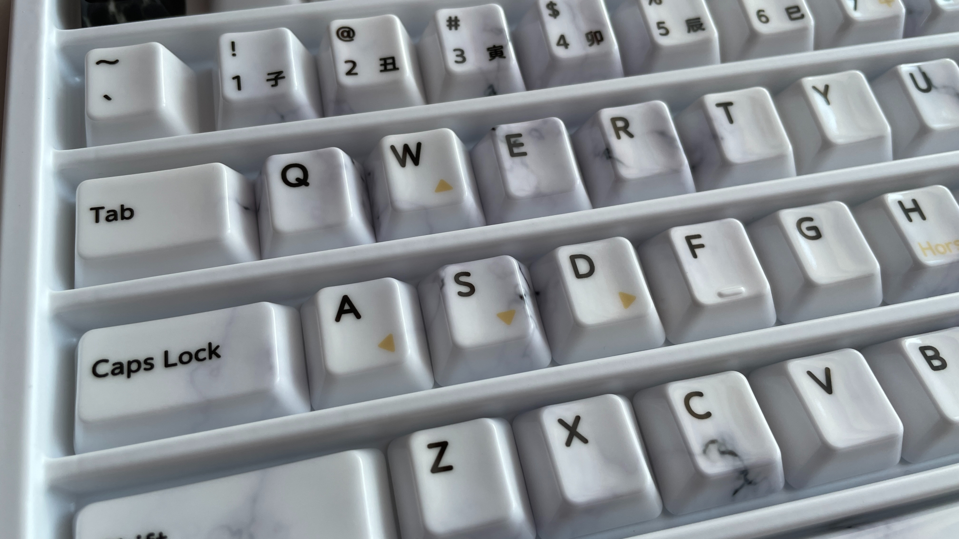XVX Ceramic Keycaps Review: Year of the Horse Keycap Set 17 WASD keycaps from the XVX Year of the Horse set with gold-colored directional arrows.