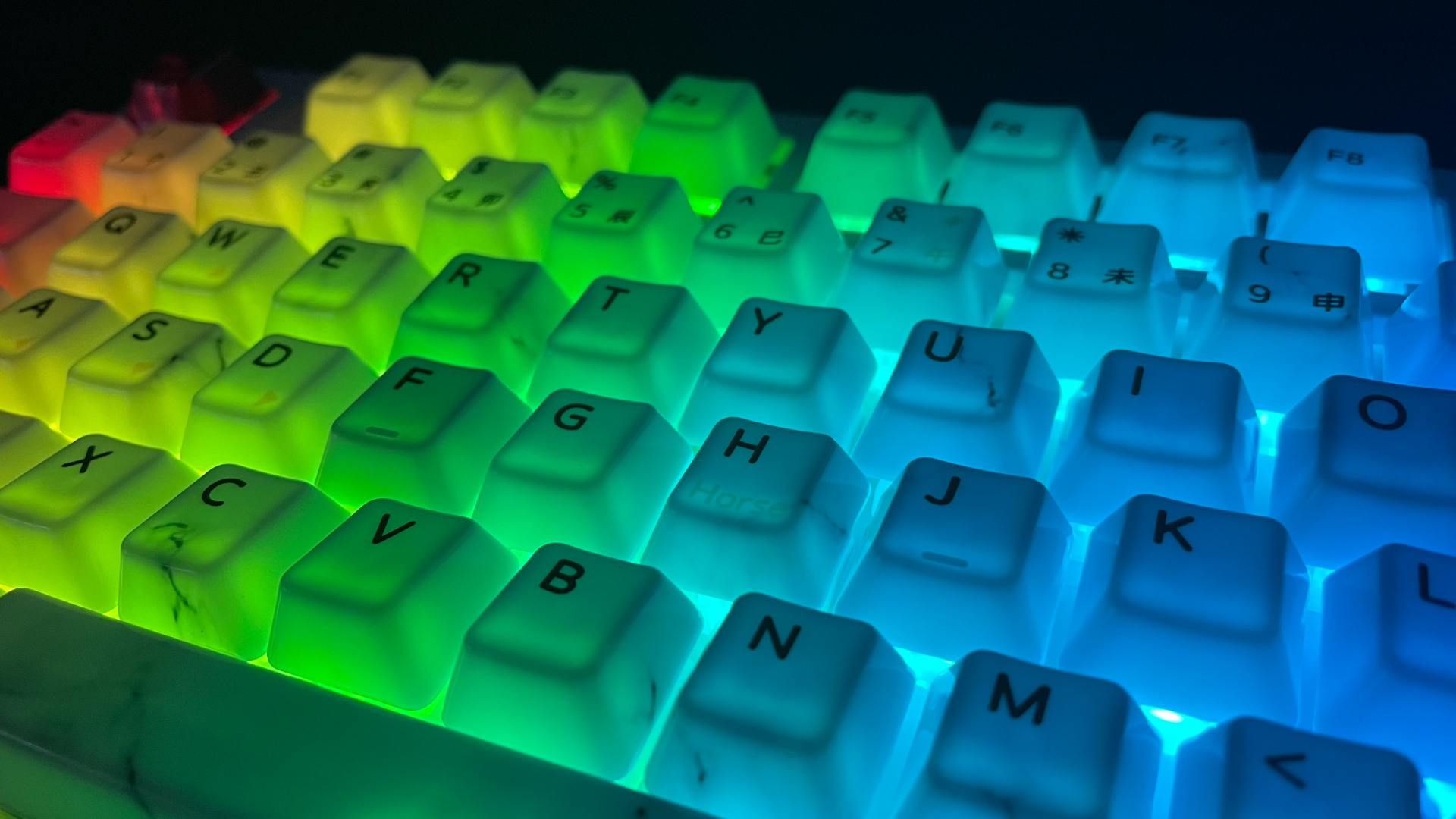 XVX Ceramic Keycaps Review: Year of the Horse Keycap Set 19 XVX Year of the Horse ceramic keycaps glowing with diffused RGB light on a keyboard in the dark.