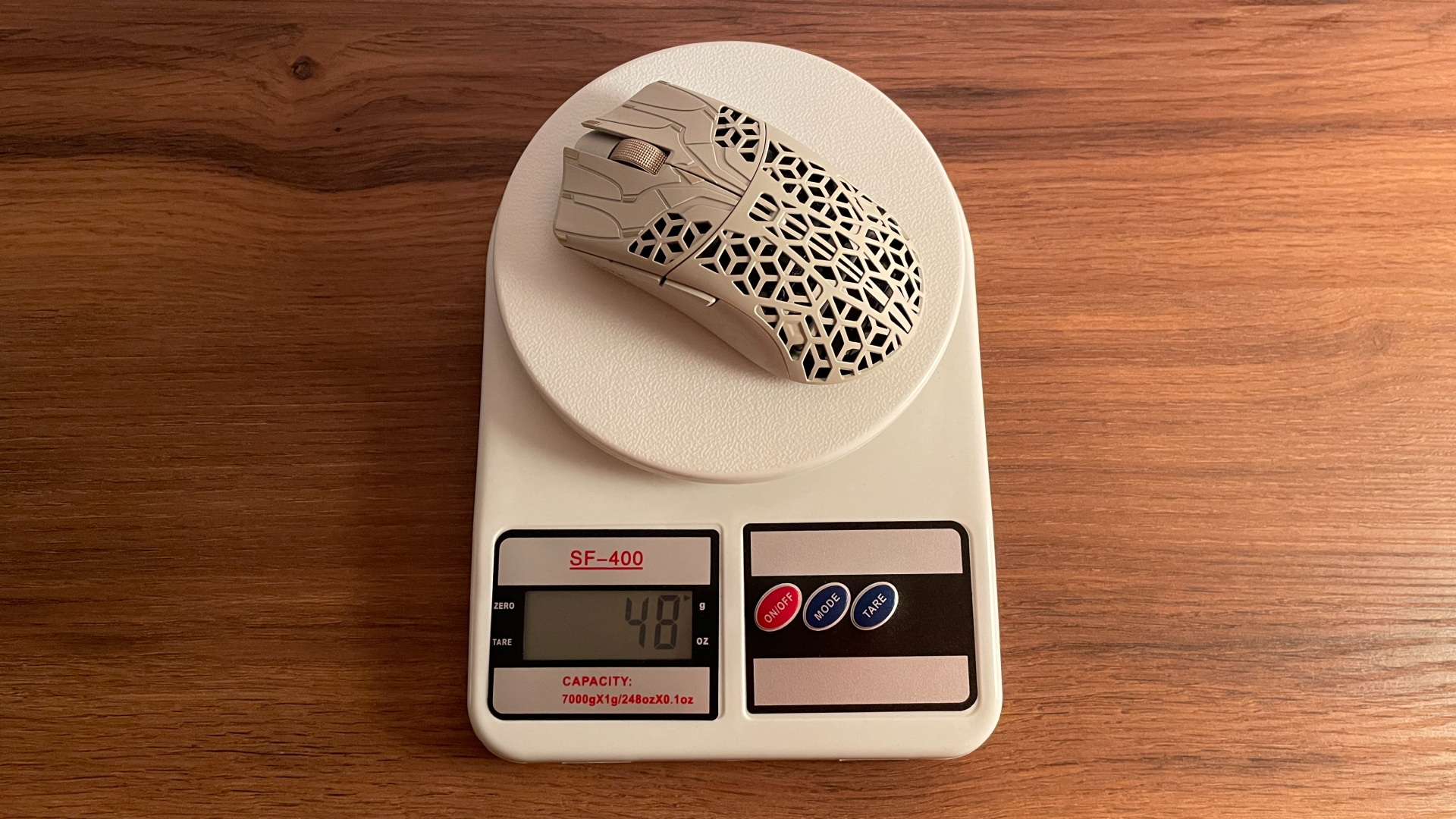 The ATK Phantom gaming mouse being weighed on a digital scale.