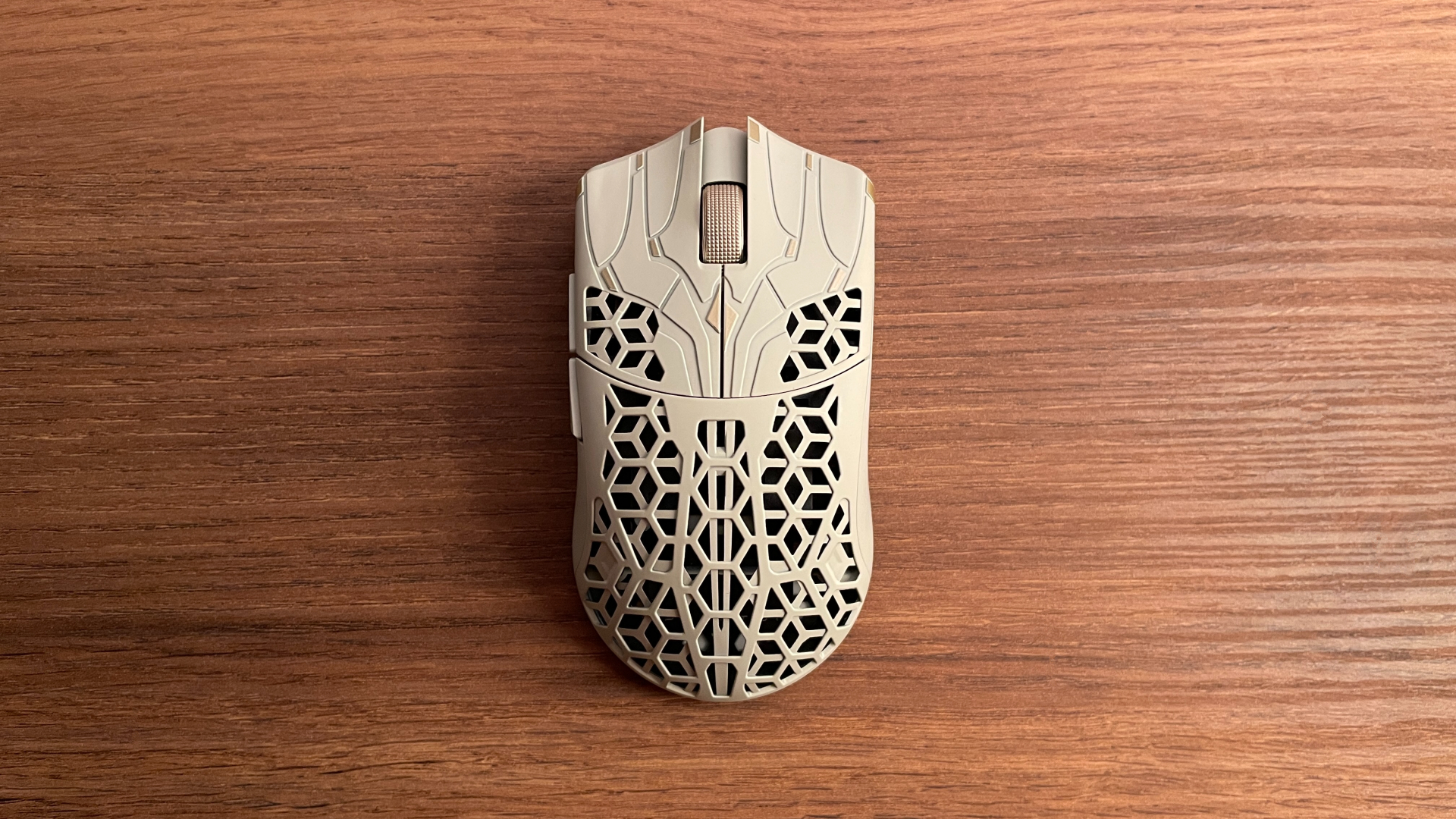 Top view of the ATK Phantom gaming mouse, showing its perforated carbon fiber shell and symmetrical shape.