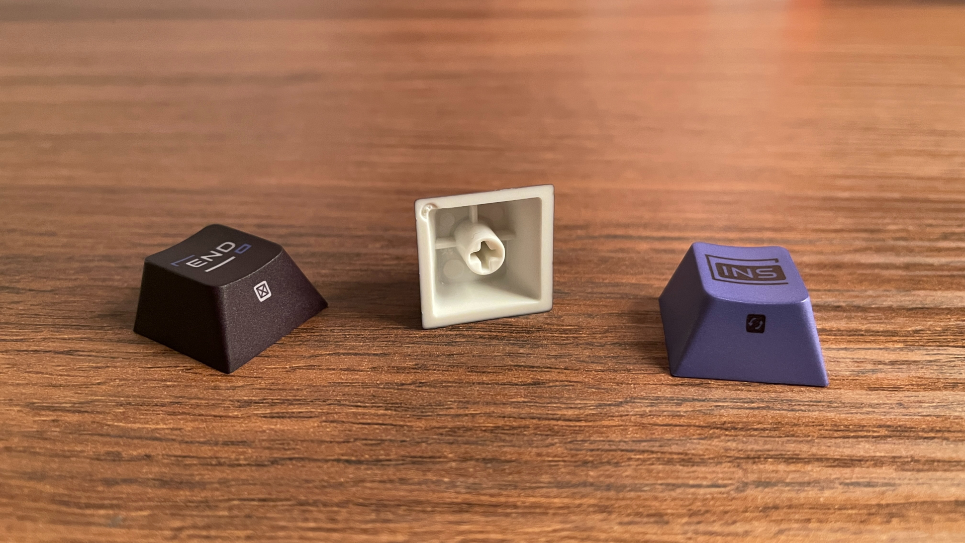 ATK RS7 V2 Ultra Review – A 75% Hall Effect Keyboard With A Twist 24 PBT keycaps from the ATK RS7 V2 Ultra on a table, with one flipped over to show its underside and wall thickness.